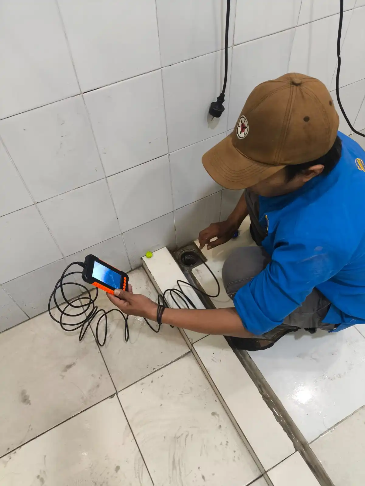 Teknisi Rooterin melakukan inspeksi pipa menggunakan drain camera